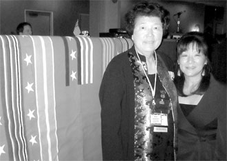Lynn Longfellow and Setsy Larouche stand in front of the Grateful Nation Blanket donated to each veteran by Pendleton.